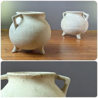 Deux grands pots de fleurs vintage ronds à trois pieds Jardinière Marmite WILLY GUHL sont posés sur un sol en bois
